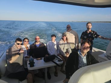A cheerful group of friends enjoys a day out on the water, capturing the essence of friendship and fun aboard a boat.