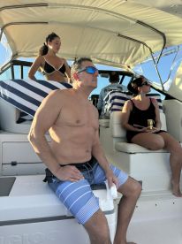 A group of friends enjoys a relaxing day on the boat, soaking up the sun and sharing drinks — perfect for a fun day out on the water.