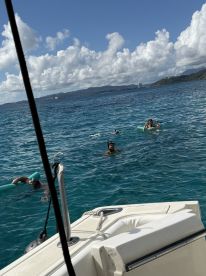A group enjoys snorkeling and swimming in crystal-clear turquoise waters, showcasing the perfect tropical getaway experience.