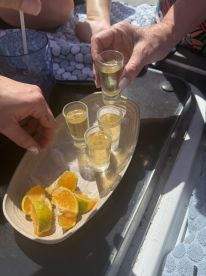 A selection of shot glasses filled with drinks and fresh citrus slices on a boat, perfect for a fun day on the water with friends.