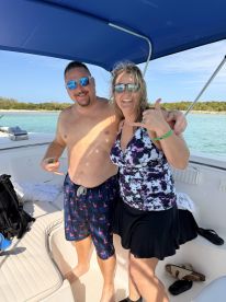 A cheerful couple poses for a fun photo on a boat, showcasing their joyful day on the water — perfect for memorable outings and celebrations.