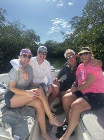 A cheerful group of friends enjoys a sunny day on a boat surrounded by lush mangroves, perfect for creating unforgettable memories on the water.
