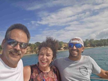 A cheerful group of friends enjoys a sunny day on the water, capturing a memorable moment aboard their boat.