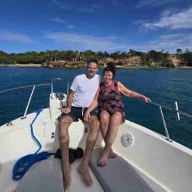 A happy couple enjoys a sunny day on a boat, surrounded by beautiful water and scenic views — perfect for romantic getaways or day trips.