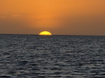 A stunning sunset over the ocean, providing a picturesque backdrop for evening boat cruises and relaxation on the water.