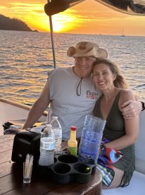 A couple enjoys a romantic sunset on a boat, surrounded by drinks and a beautiful ocean view — perfect for special occasions or intimate getaways.