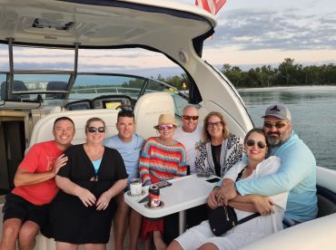 A cheerful group of friends enjoys a memorable moment aboard a boat, perfect for celebrations and social gatherings on the water.