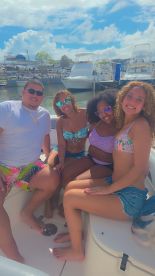 A group of friends enjoys a sunny day on a boat, capturing the essence of fun and camaraderie on the water.