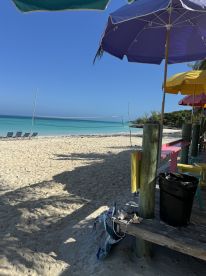 A serene beach scene featuring colorful umbrellas and lounge chairs, perfect for a relaxing day by the water.