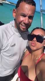 A cheerful couple poses for a selfie at the beach, capturing a fun moment in the sun — perfect for sharing memories of their tropical getaway.