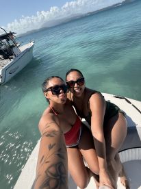 Two friends take a joyful selfie on the deck of a boat, enjoying a sunny day on the water — perfect for memorable outings and celebrations.