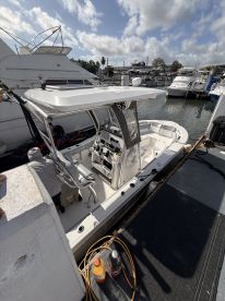 A detailed view of the interior helm and seating area of a boat, showcasing the console and equipment, with a person visible in the background.
