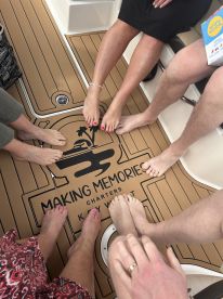 A fun group photo showcasing feet on the deck of a boat, capturing the spirit of camaraderie and relaxation during a charter experience in Key West.