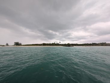 A cloudy scene over water with an island in the background, but the image lacks clarity and detail.