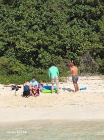 A lively group enjoys a beach day, engaging in fun activities on the sand — perfect for family outings and memorable moments in the sun.