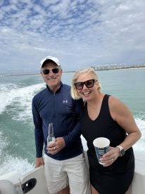 A cheerful couple enjoys drinks on a boat, capturing the joy of a perfect day on the water. Ideal for celebrating special moments or just relaxing in the sun.