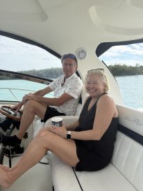 A couple enjoys a relaxing moment inside the cabin of a Sea Ray boat, showcasing comfortable seating and a scenic view through the windows.