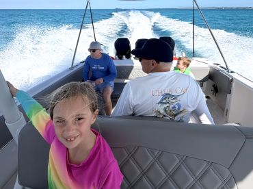 A joyful family enjoys a boat ride, capturing the thrill of on-water activities with smiles and laughter. Perfect for family outings in beautiful turquoise waters.