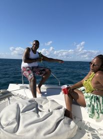 A joyful moment on a yacht as two friends enjoy drinks and the beautiful ocean view, perfect for a fun day on the water.