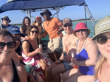 A lively group of friends enjoys a fun day on the water, sharing drinks and laughter aboard their boat — perfect for memorable celebrations and adventures.