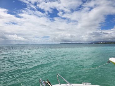 A serene view of turquoise waters under a partly cloudy sky, showcasing the beauty of the ocean — perfect for a relaxing day on the water.