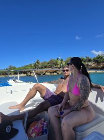 A couple enjoys a sunny day on a boat, soaking in the beautiful surroundings — perfect for a relaxing getaway on the water.