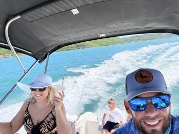 A joyful family enjoys a day on the water, capturing smiles and fun moments while cruising on a boat — perfect for family outings and adventures.
