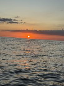 A stunning sunset over the ocean, creating a picturesque backdrop perfect for evening boat cruises and serene moments on the water.