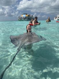 A joyful interaction as a girl swims with a stingray in crystal-clear waters, showcasing a unique wildlife experience in a tropical paradise.