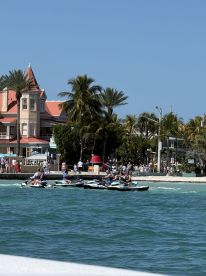 A group of jet skiers enjoy a thrilling ride along the coastline, with a vibrant beach scene in the background — perfect for adventure seekers in sunny locales.
