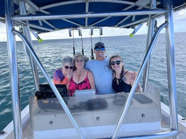 A joyful group of friends poses together on a boat, capturing a memorable moment on the water — perfect for celebrating adventures and camaraderie.
