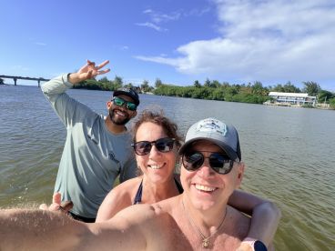 A cheerful group poses for a selfie by the water, capturing a fun moment during their boating adventure. Perfect for showcasing memorable experiences on the water.