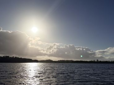 A stunning sunset over tranquil waters, with clouds reflecting the golden light — a perfect backdrop for evening boat trips or peaceful moments on the water.