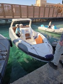 A sleek speedboat named 'Sunghida' docked at a marina, showcasing its stylish design and clear turquoise waters — perfect for a day of adventure on the sea.