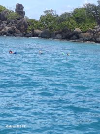 Two snorkelers enjoy the vibrant waters while exploring the underwater world, surrounded by stunning natural scenery.