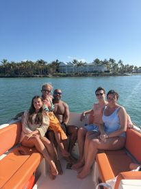 A cheerful group of friends enjoys a sunny day on a boat, capturing the essence of fun and relaxation on the water.
