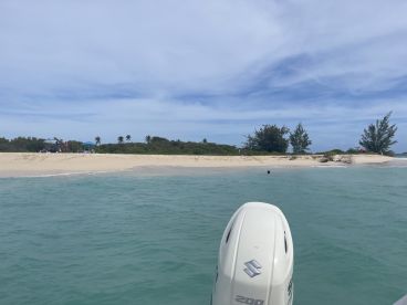 A scenic view of a sandbar with people enjoying the beach and swimming in the clear waters — a perfect destination for relaxation and fun in the sun.