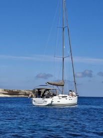 A beautiful sailboat navigates through clear waters, showcasing a perfect day for sailing adventures.