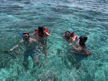 A group of friends enjoys snorkeling in crystal-clear waters, showcasing the fun and adventure of underwater exploration.