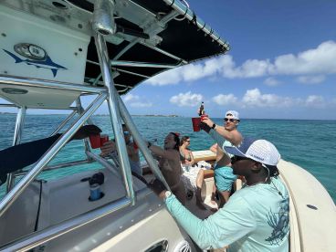 A lively group enjoys drinks aboard a boat, celebrating together under the sun — perfect for memorable outings on the water.