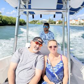 A couple enjoys a scenic boat ride, capturing the joy of their water adventure with a friendly captain at the helm.