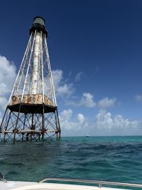 A stunning view of a historic lighthouse standing tall over turquoise waters, perfect for capturing the beauty of coastal landmarks.