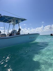 A close-up view of the 'Easy Jest' boat navigating through clear turquoise waters, showcasing its sleek design and sunny day ambiance.