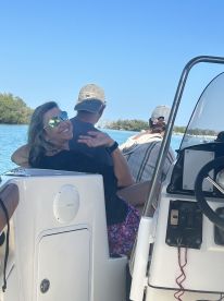 A joyful moment captured on a boat with friends, showcasing smiles and the beautiful water backdrop — perfect for memorable outings on the water.
