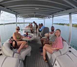 A lively group enjoys their time aboard a pontoon boat, perfect for socializing and celebrating on the water.