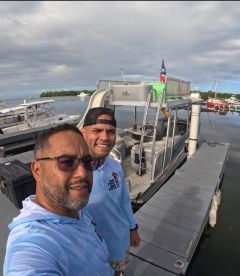 Two friends pose for a selfie on a boat dock, capturing a moment of camaraderie before their adventure on the water.