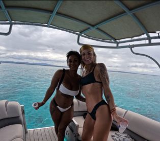 Two friends pose happily on a boat, enjoying their time on the water — perfect for a fun day out with friends.