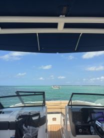 A view from the helm of a boat, showcasing the comfortable seating and dashboard, perfect for navigating the beautiful turquoise waters.