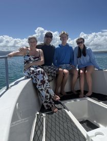 A family enjoys a sunny day on a boat, capturing a memorable moment together on the water.