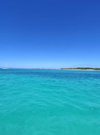 A scenic view of turquoise waters under a clear blue sky, showcasing the beauty of a tropical destination.